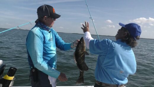 Captain Sergio and Captain George reel in a Grouper